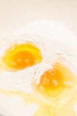 Top view of smashed eggs in flour ready for creating dough