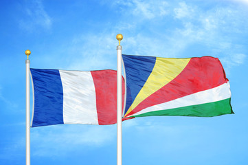 France and Seychelles two flags on flagpoles and blue cloudy sky