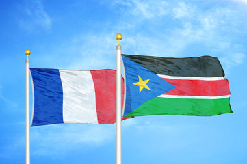 France and South Sudan two flags on flagpoles and blue cloudy sky