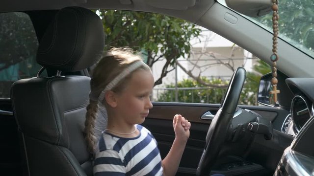 girl sitting in a car and dancing listening to music