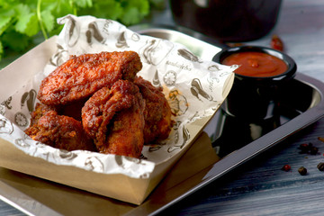 spicy chicken wings with barbecue sauce in delivery package