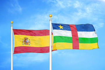 Spain and Central African Republic  two flags on flagpoles and blue cloudy sky