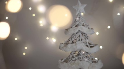 Christmas tree composition with falling snow and defocused lights in foreground and background. Slow motion dolly shot. Shallow depth of field.