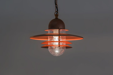 Modern streamlined mirror copper chandelier. Metal classic lantern isolated on gray background