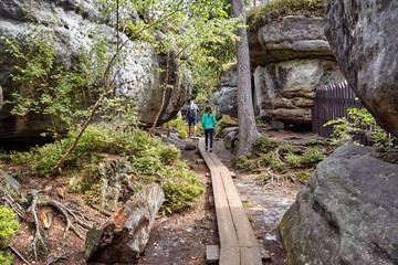 Tourists visiting Errant Rocks (Błędne Skały)- a series of gorges, crevices, cracks, shelters and small caves, formed by erosion located in the Table Mountains National Park, Poland