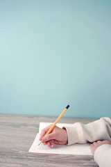 Kid writing something in notebook. Class, study, memo, learning,...