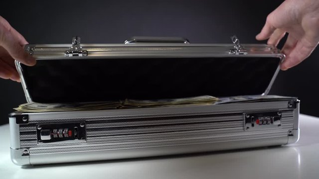 Open a metal suitcase with dollar bills. Close-up