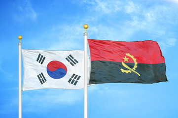 South Korea and Angola  two flags on flagpoles and blue cloudy sky