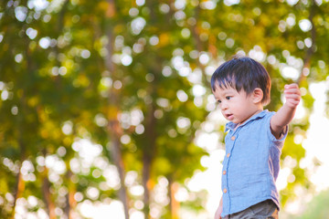 Portrait of adorable little boy playing in city park blurred bokeh background