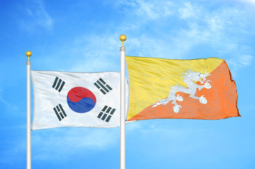 South Korea and Bhutan  two flags on flagpoles and blue cloudy sky