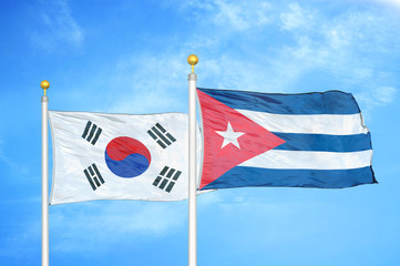 South Korea and Cuba two flags on flagpoles and blue cloudy sky