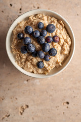 Top View of Bowl of Oatmeal with Blueberries on Top Copy Space