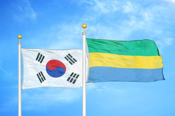 South Korea and Gabon two flags on flagpoles and blue cloudy sky
