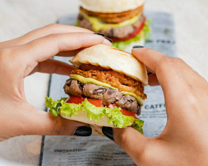 Women's hands holding a healthy vegan burger made with bean meat