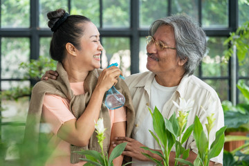 Healthy Asian senior couple man and woman relaxing together in greenhouse garden. Retirement old age family enjoy romantic moment at home. Elderly person with leisure lifestyle and healthcare concept.