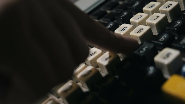 Extreme close up of fingers dialing numbers on vintage cashbox