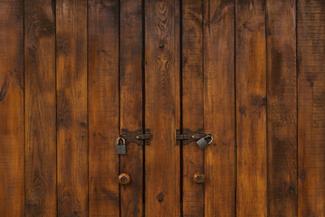 Powerful wooden doors with padlocks. Dark Wood texture.