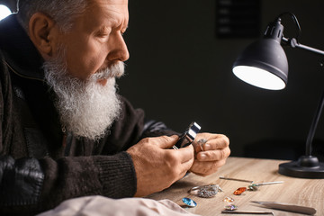 Jeweller examining adornment in workshop