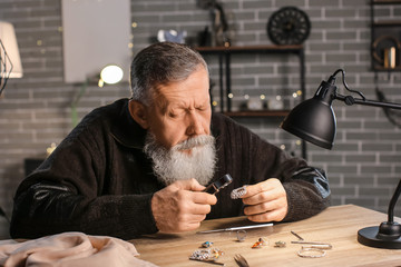 Jeweller examining adornment in workshop