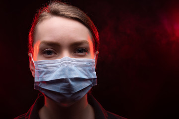 Coronavirus infected woman in a protective mask on a black and red background. National problem of...