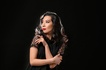 Naklejka premium Young Asian woman with beautiful hair on dark background