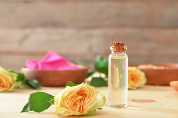 Fototapeta na wymiar Bottle of rose essential oil on table