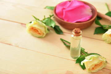 Bottle of rose essential oil on table