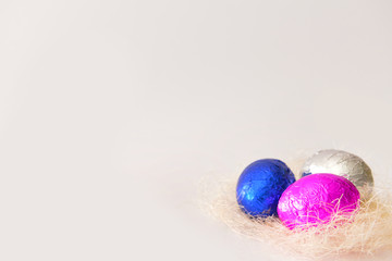 Fototapeta na wymiar Nest with sweet chocolate eggs on white background