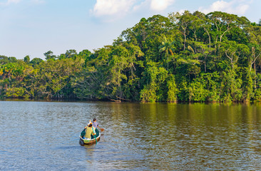 Fototapeta na wymiar A group of people on a bird watching tour in a canoe, Amazon Rainforest, Yasuni national park, Ecuador.