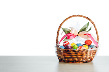 Fototapeta na wymiar Easter gift basket with multicolor eggs, white background