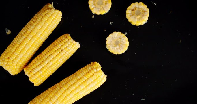Pieces of corn fall on the water splashes.