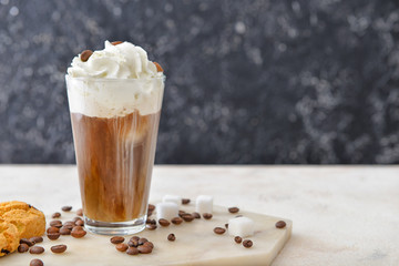Glass of tasty iced coffee on table