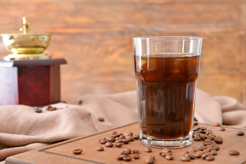 Glass of tasty iced coffee on table