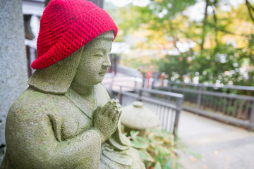 Nanzoin temple, Fukuoka Japan- November 21, 2018: Small statue press the hands together and wear red wool hat at Nanzoin temple in Autumn