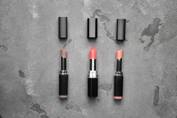 Different lipsticks on grey background