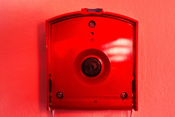 Bright red fire alarm button on the wall