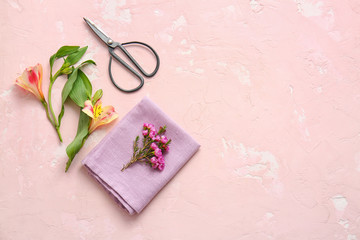 Napkin with floral decor prepared for table setting on color background