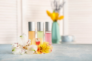 Roll-on perfumes and flowers on table