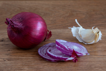 Red onion and garlic on a wooden surface.