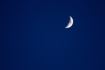 Obraz na płótnie Canvas Crescent moon in the blue sky satellite crater copyspace