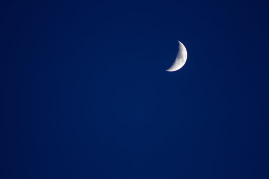 Crescent moon in the blue sky satellite crater copyspace