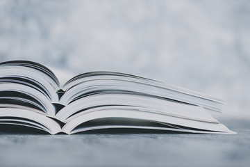 education and self-improvement, pile of open books shot from eye level with shallow depth of field
