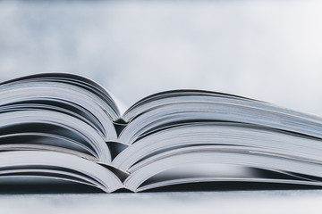 education and self-improvement, pile of open books shot from eye level with shallow depth of field