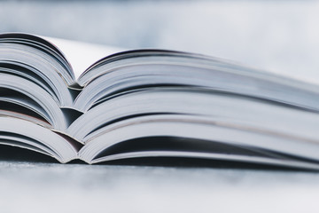 education and self-improvement, pile of open books shot from eye level with shallow depth of field