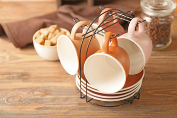 Holder with cups and saucers on kitchen table