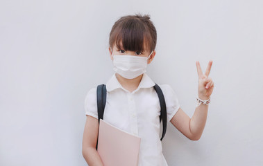 Little girl wearing mask protect from virus and air pollution go to school. Coronavirus and PM 2.5. Portrait. Close up.