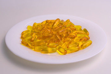 
Useful omega 3 capsules on a plate. Close-up.