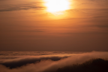 Beautiful sunrise above the clouds in the mountains