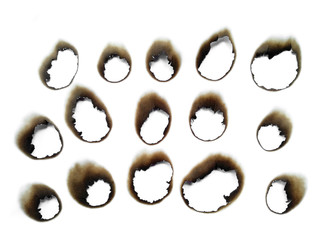 Collection of burnt holes in a piece of paper isolated on white background. Fire holes in white paper.