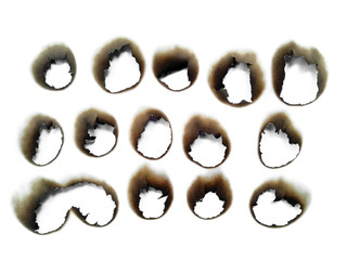 Collection of burnt holes in a piece of paper isolated on white background. Fire holes in white paper.